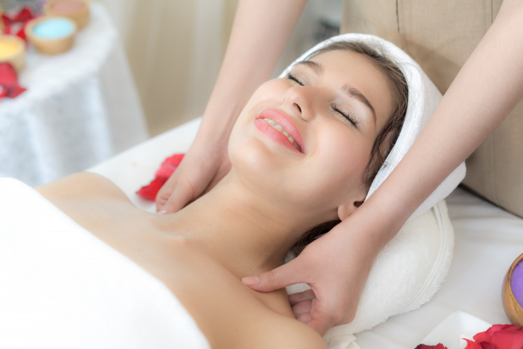 woman smiling while having her collarbone massaged