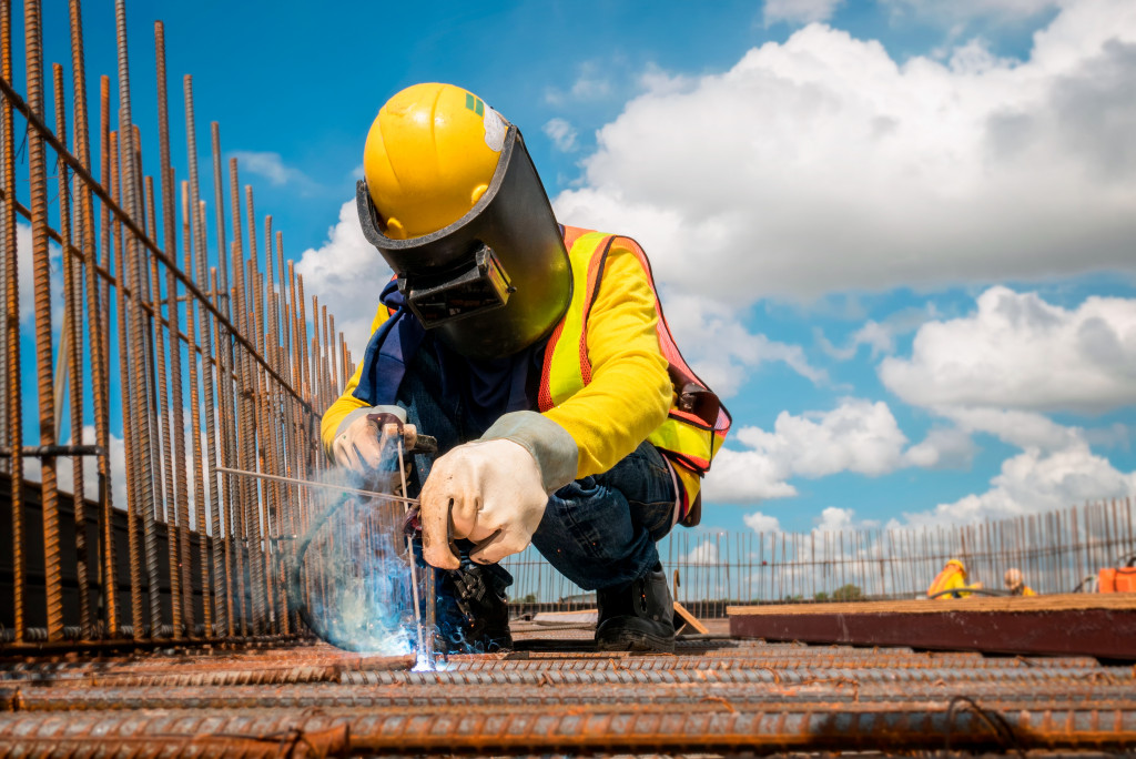 a construction worker welding a metal rod
