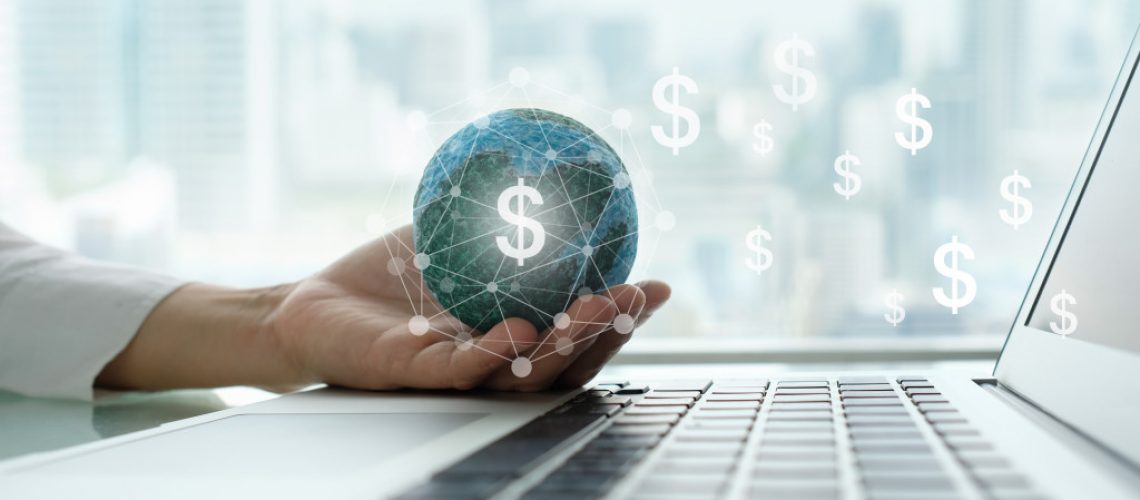 hands holding a digital currency while using the laptop
